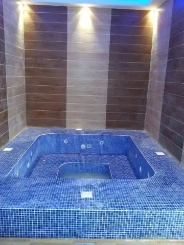 Indoor spa with ceiling downlights and blue mosaic