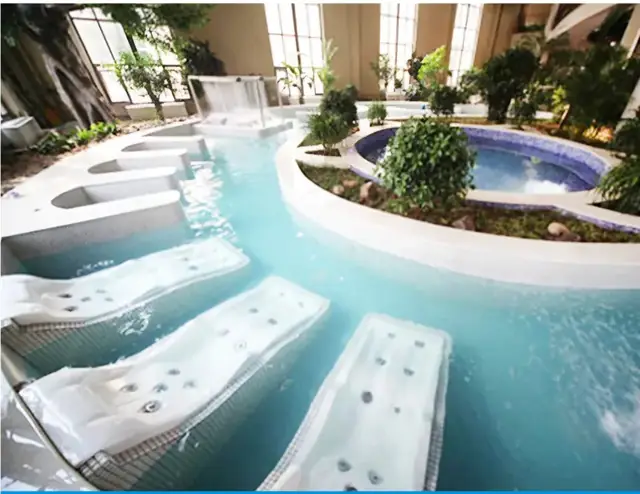 Indoor leisure pool with massage beds and a round spa