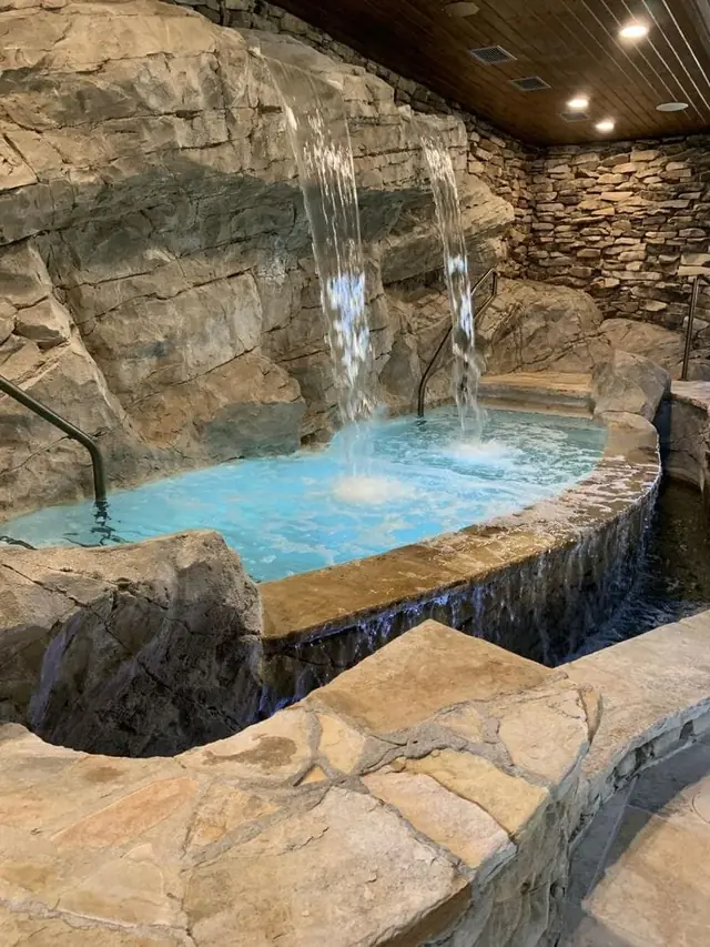 Whirlpool with rock waterfall and stone cladding