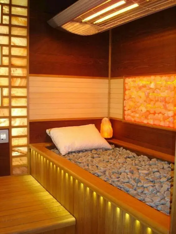Salt room with illuminated Himalayan wall and pebble bed