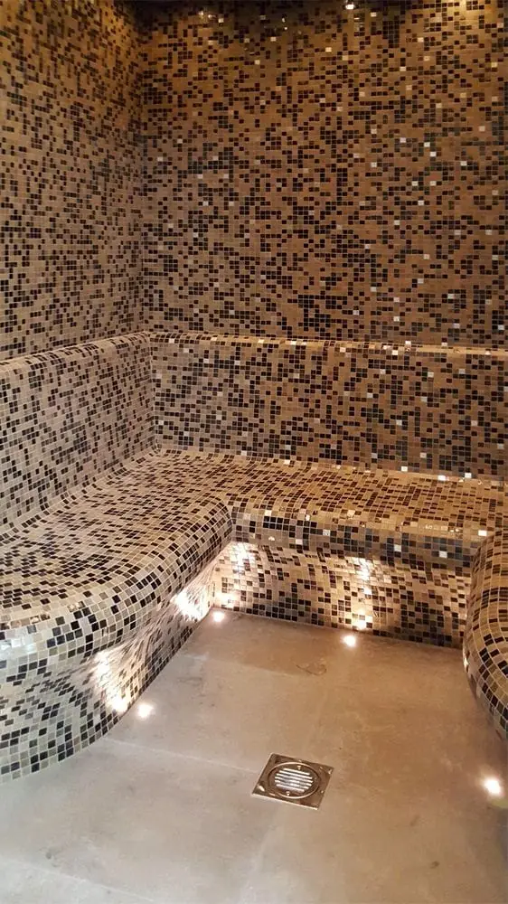 Steam room with mosaic benches and point lighting