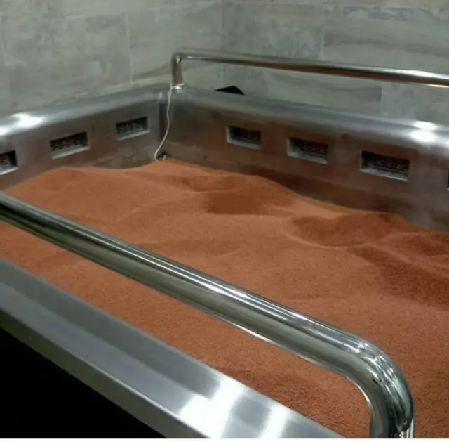 Heated volcanic-sand bed with stainless frame